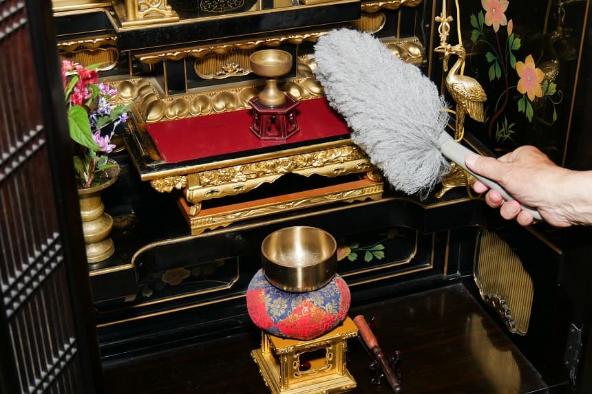 仏壇をモップで掃除している様子