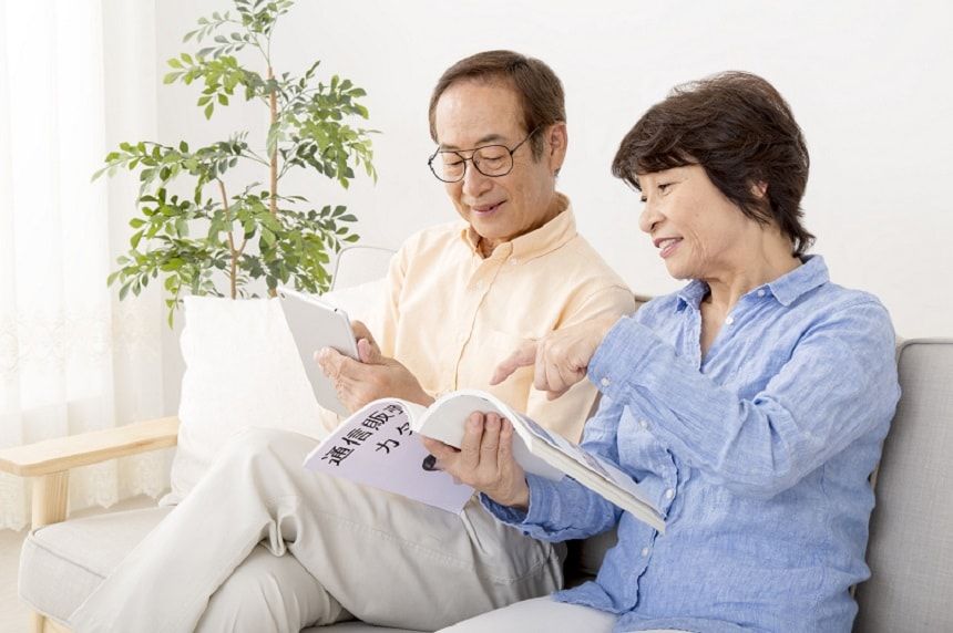 カタログを見て話し合う老夫婦