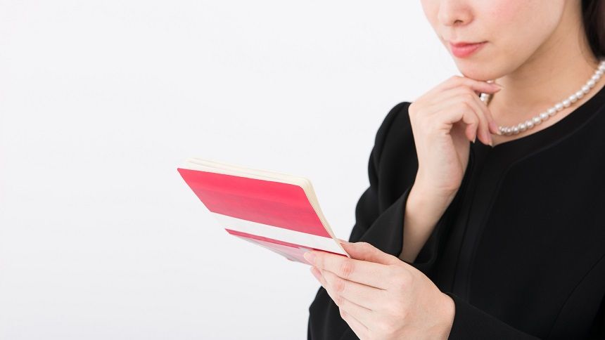 通帳を見て考える女性