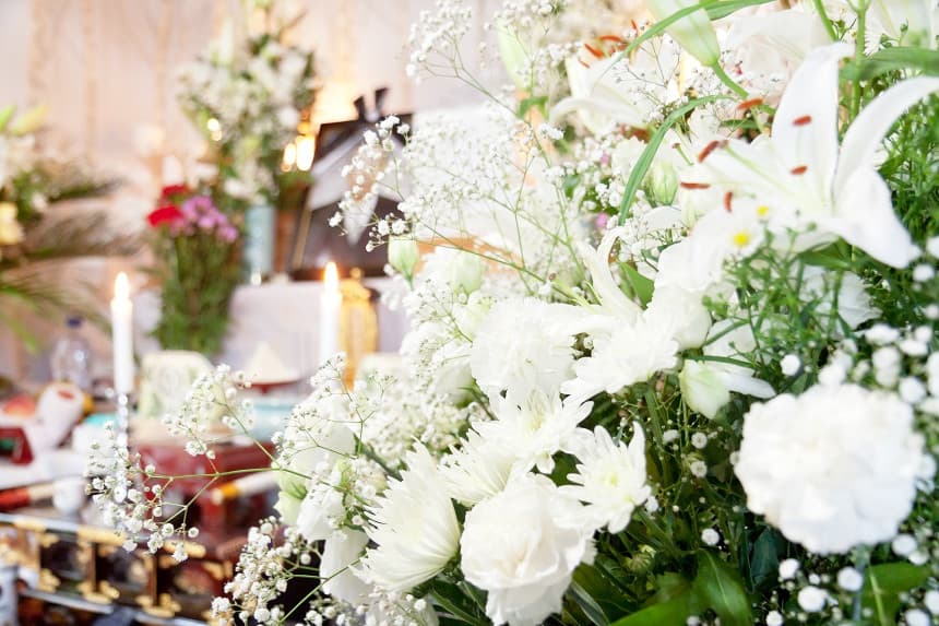白い供花が飾られている祭壇