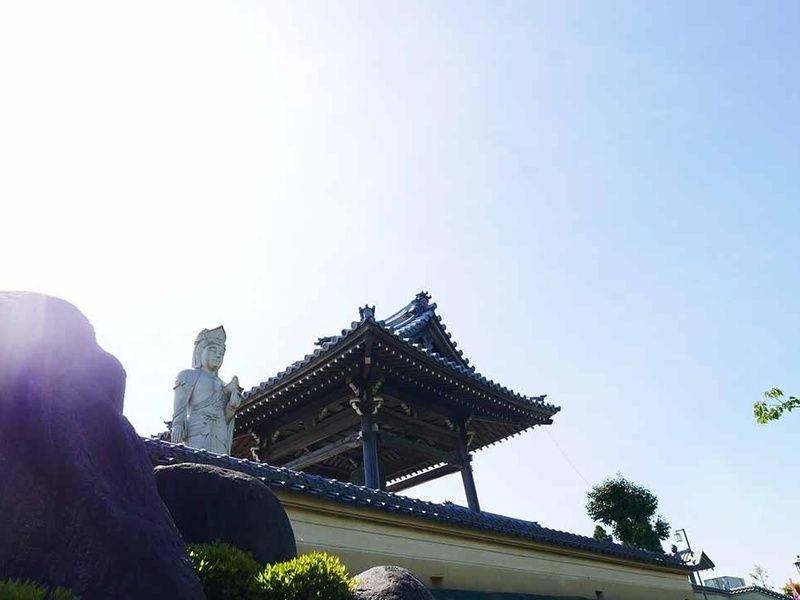 大通りから見た 幸運観世音菩薩（左）と幸運の鐘（右）